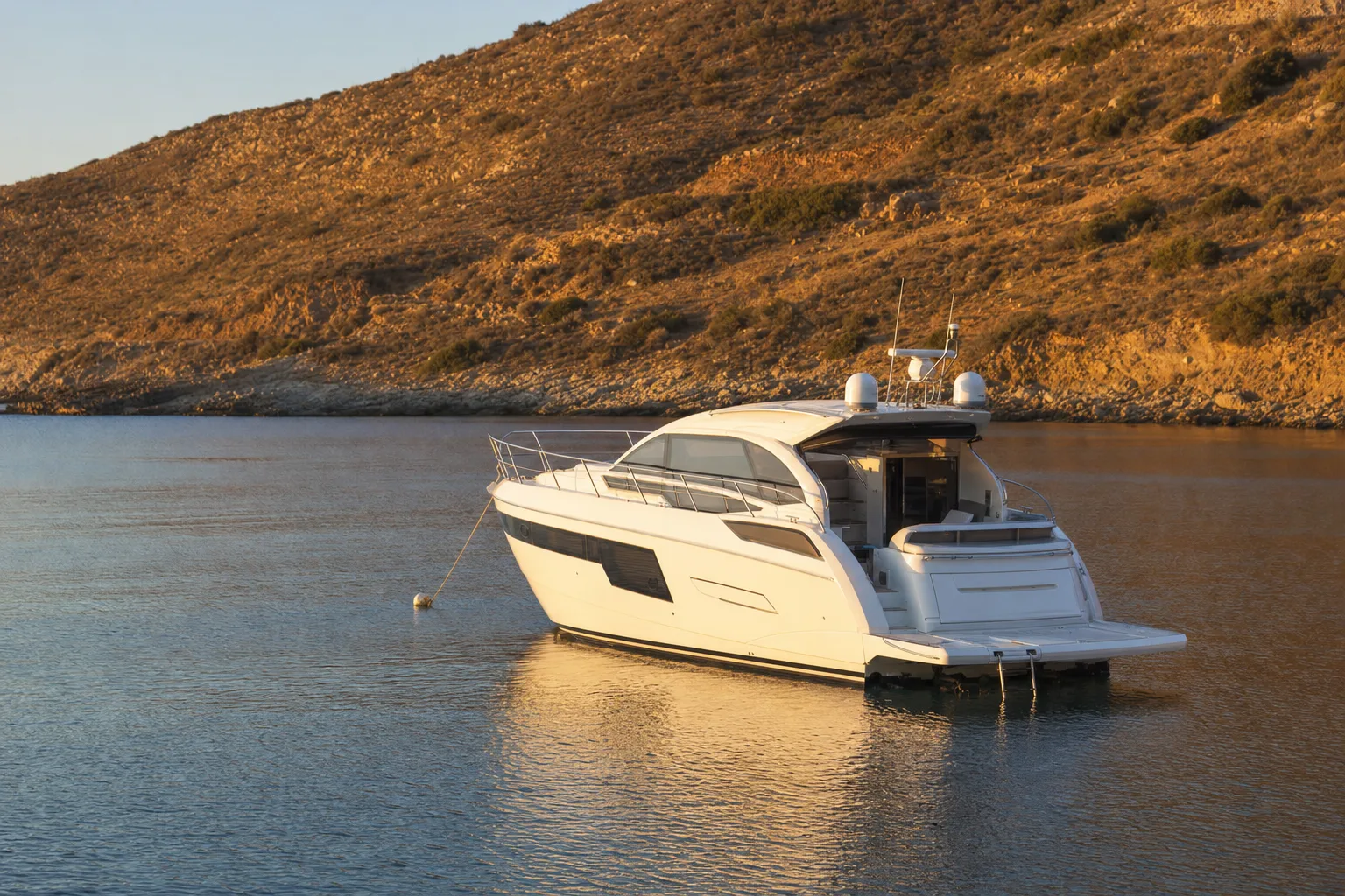 A crewed charter yacht at anchor alone in an empty late-season bay